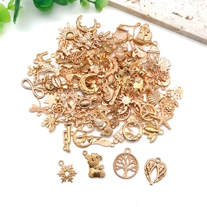 Detailed view of assorted gold alloy pendants featuring moon, stars, and flora for DIY jewelry