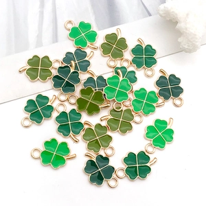 Detail shot of assorted green enamel four-leaf clover charms with gold alloy edges for DIY jewelry