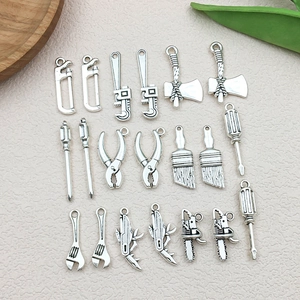 Detailed close-up of vintage silver alloy miniature tool charms for DIY accessories