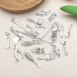 Macro view of vintage silver alloy miniature hardware tool pendants for DIY jewelry