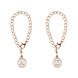 Golden letter A and D charms on O-chain bracelets with lobster clasps on white background