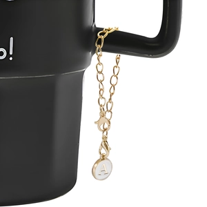 Macro shot of gold alloy letter A pendant chain on black cup handle with lobster clasps