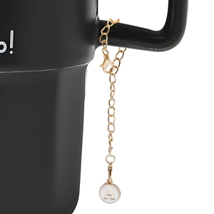 Detail view of a gold lobster clasp chain with letter A pendant on a black handle