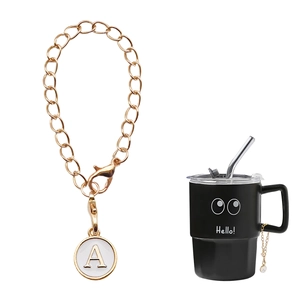 Golden keychain with letter A charm and lobster clasp shown on a black mug handle