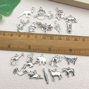 Detailed macro view of assorted antique silver animal charms with size reference scale