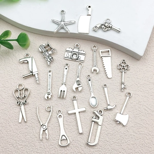 Detailed flat lay of assorted vintage silver alloy tool charms for DIY jewelry making