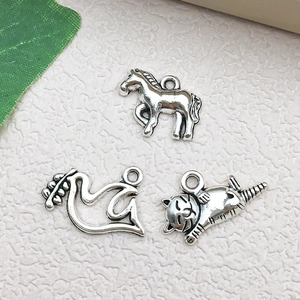 Macro detail of vintage silver animal pendants showing horse bird and cat textures