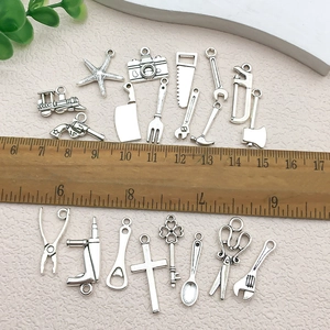 Assorted antique silver alloy charms set for DIY jewelry making with ruler scale reference
