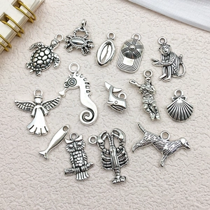 Macro detail of 14 vintage silver alloy charms featuring animals and mixed shapes for DIY