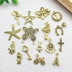 Assortiment vintage goudkleurige bedeltjes met zeester, vlinder en diverse sleutels