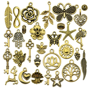 Assorted antique gold alloy charms set featuring feathers hearts and trees for DIY jewelry