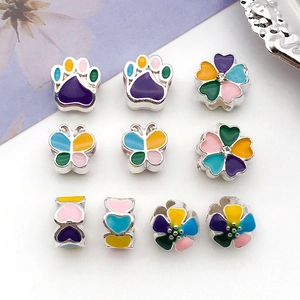 Macro detail of colorful enamel heart and butterfly beads for DIY jewelry making