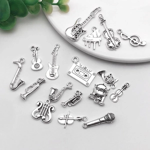 Close-up of vintage silver music charms featuring guitar violin and saxophone shapes