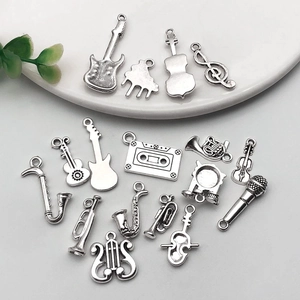 Flat lay of antique silver music instrument charms including guitar and saxophone charms