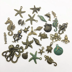 Detailed macro view of vintage bronze sea life charms including starfish and seahorses