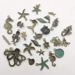 Detailed macro view of vintage bronze marine life charms including seahorse and starfish