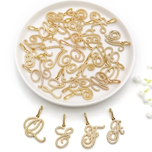 Detailed close-up of cursive golden alphabet pendants with sparkling pavé crystals
