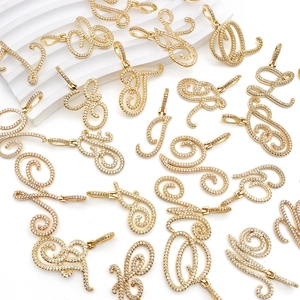 Detail of cursive capital letter pendants in gold finish with micro-pave zirconia stones