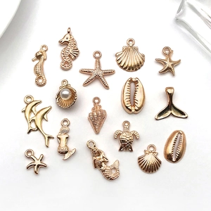 Macro detail of rose gold ocean charms including seahorse, starfish and shell with pearl