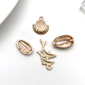 Detailed macro view of golden alloy sea life charms for DIY necklace and bracelet crafting