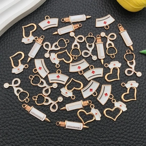 Detailed macro of enamel medical charms including syringe and stethoscope for DIY jewelry