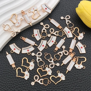 Macro shot of gold-plated alloy medical charms with enamel finish on black leather