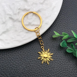 Golden sun pendant keychain with detailed radial rays and polished alloy finish
