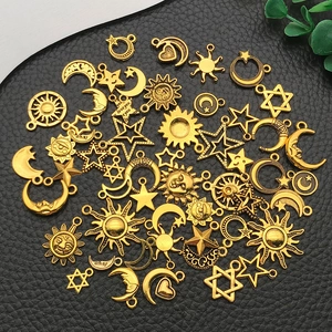 Macro detail of antique gold sun, moon, and star charms for DIY jewelry making