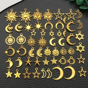 Macro view of gold celestial pendants with sun and moon motifs for DIY jewelry making