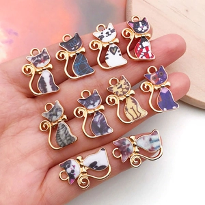 Vue détaillée de divers pendentifs chat en émail pour la fabrication de bijoux DIY sur paume