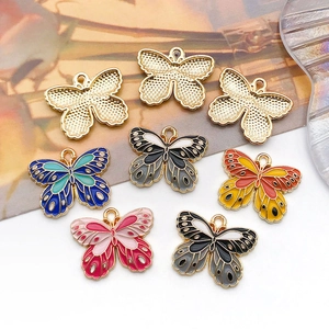 Macro shot of 8-piece butterfly charms showing colorful enamel designs and gold metal back
