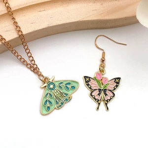 Detailed close-up of moth and butterfly charms with green and pink enamel finish
