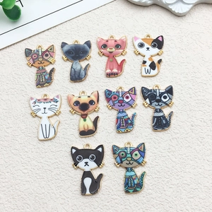 Vue à plat de dix breloques chat en émail et alliage pour la création de bijoux DIY