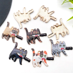 Detailed macro view showing diverse enamel cat with knife pendants and metallic back texture
