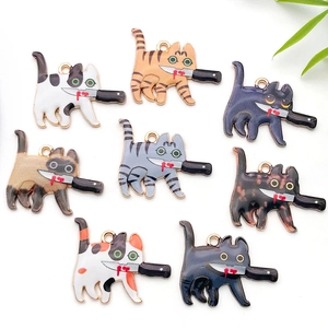 Detailed macro view of cat alloy pendants in various colors holding a black knife