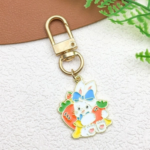 Detail view of Easter bunny alloy pendant with blue bow and carrots on gold clasp