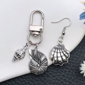 Silver shell and conch pendants on keychain and earring with ocean theme vintage metal texture