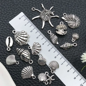 Detailed macro view of vintage silver sea shell charms showing varied sizes and textures