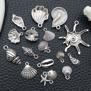 Macro view of assorted vintage silver ocean charms including shells and sea stars