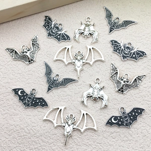 Detailed close-up of antique silver bat charms for Halloween DIY jewelry making