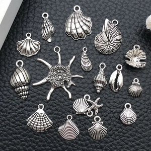 Macro view of silver ocean-themed pendants including scallop shells and sea stars