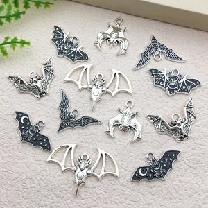 Macro detail of assorted bat charms in silver and black enamel for DIY jewelry making