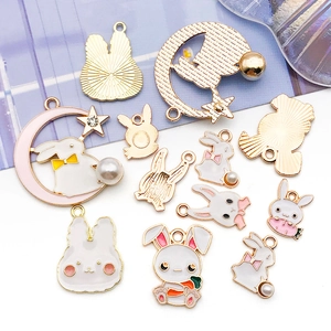 Detailed view of enamel rabbit and moon charms with pearls and rhinestones for DIY jewelry