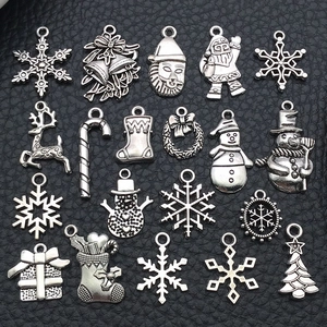Détail de breloques de Noël argentées comprenant flocons et rennes pour la création de bijoux DIY