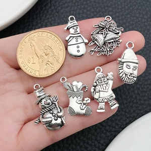 Détail de breloques de Noël en argent antique avec bonhomme de neige et cloche pour bijoux