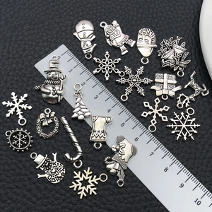 Vue détaillée de breloques de Noël en argent antique avec règle pour référence de taille