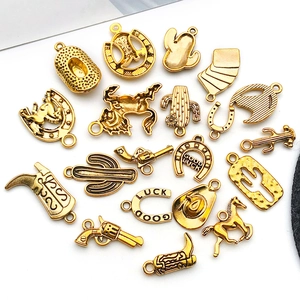 Detailed flat lay of assorted golden alloy charms with western cowboy and horseshoe motifs