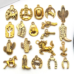 Detail of vintage gold horseshoe, cowboy hat and cactus charms for DIY jewelry making