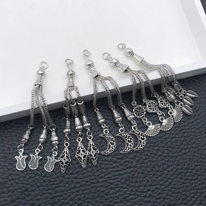 Detail of five vintage silver alloy tassel pendants for DIY jewelry and prayer beads