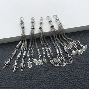 Detailed macro view of five vintage silver alloy tassel pendants on black leather
